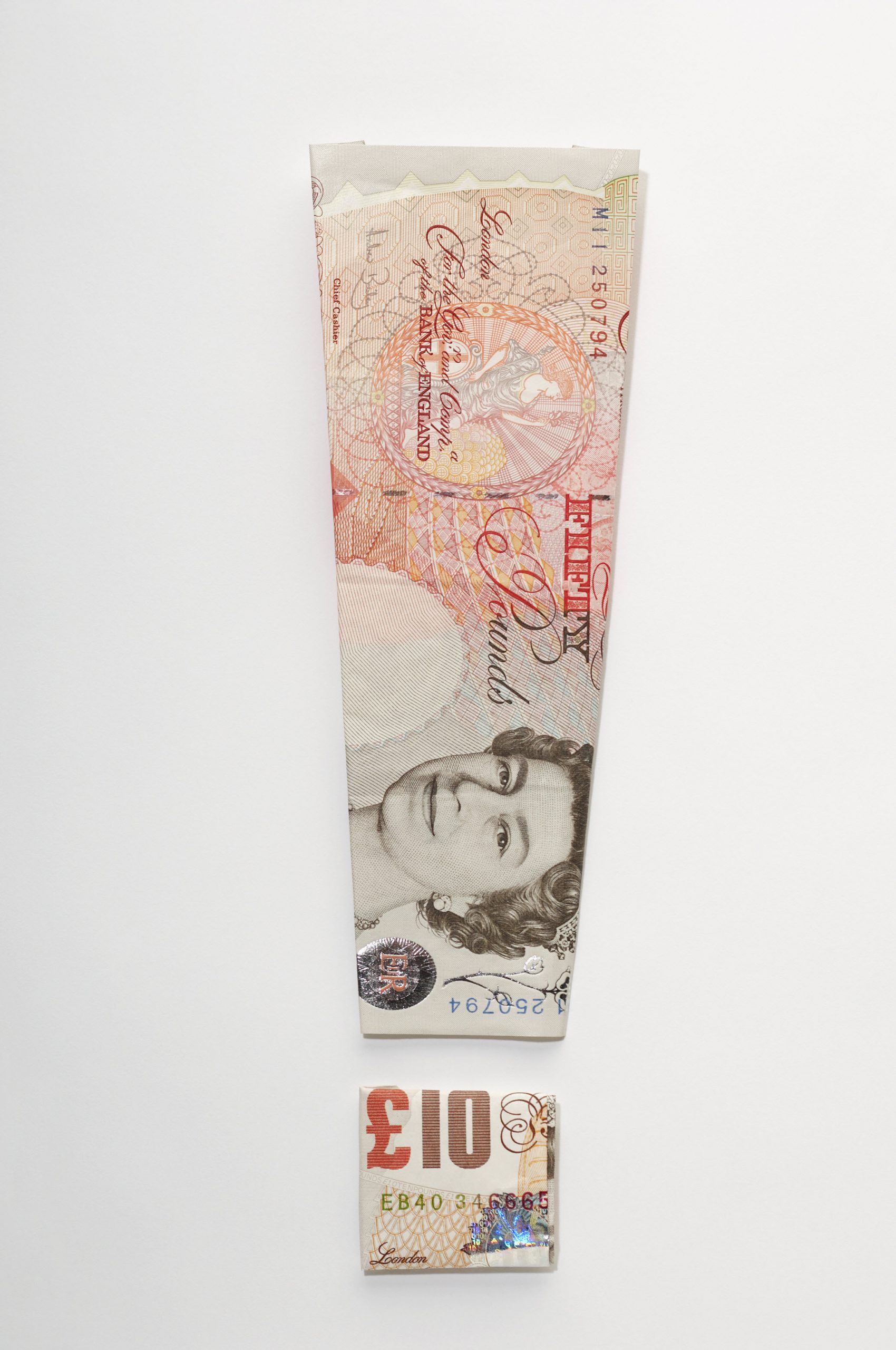Exclamation mark symbol made of folded banknotes